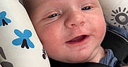 Grayson is registered to the contest to win money with this photo: baby, infant, child, smiling, happy, face, portrait, sitting, harness, seat, patterned_fabric, blue_clothing, indoor, close_up, eyes, mouth, cheeks, baby_gear, photography, safe