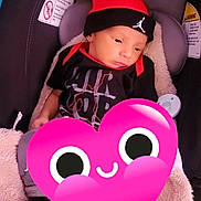 Kaylin Marcus is registered to the contest to win money with this photo: baby, infant, car_seat, blanket, hat, clothing, red, black, indoor, child, portrait, cute, warm, bundle, seat, warning_label, headwear, soft, comfort, expression