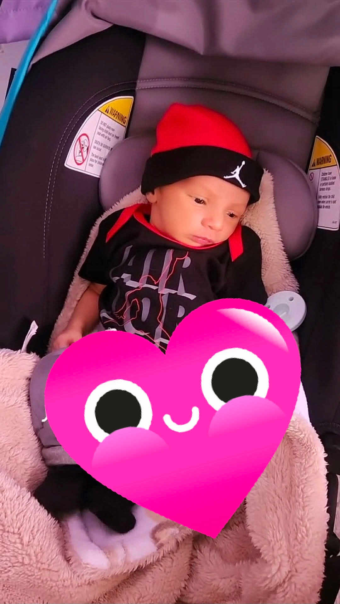 Kaylin Marcus is registered to the contest to win money with this photo: baby, infant, car_seat, blanket, hat, clothing, red, black, indoor, child, portrait, cute, warm, bundle, seat, warning_label, headwear, soft, comfort, expression