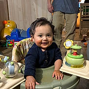 Koda joined the competition — help win amazing prizes! baby, child, walker, toy, indoor, smiling, face, person, family, play, furniture, clothing, floor, adult, background, happy, curly_hair, messy_face, home, flooring