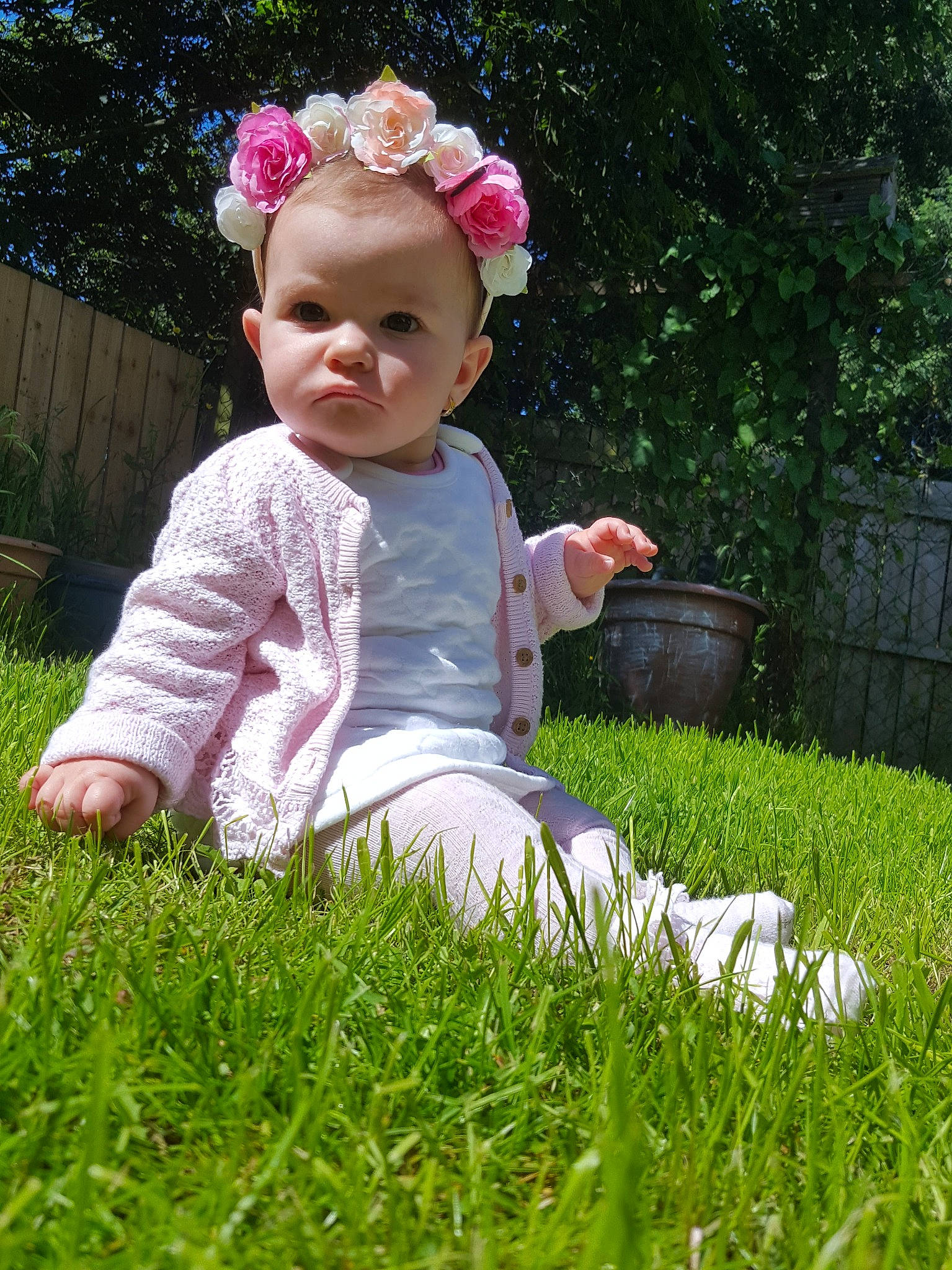 Carina is registered to the contest to win money with this photo: baby, baby_toddler_clothing, botany, child, flower, garden, grass, grass_family, hair_accessory, lawn, meadow, people_in_nature, person, pink, plant, play, sitting, skin, spring, summer