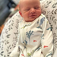 Maverick joined the competition — help win amazing prizes! baby, sleeping, onesie, dinosaur_print, infant, cozy, cushion, leaf_pattern, peaceful, cute, child, soft, indoor, portrait, face, newborn, resting, comfort, clothing, young