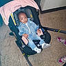 baby, denim_jacket, baby_carrier, pink_canopy, indoor, floor_tiles, sneakers, child, casual, curious, seated, footwear, jeans, person, infant, portrait, clothing, cute, looking_at_camera, hand