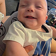 Brayden joined the competition — help win amazing prizes! baby, smiling, infant, person, hand, clothing, white_shirt, indoor, holding, happy, cute, face, skin, baby_arm, logo, closeup, child, joy, blurred_background, casual