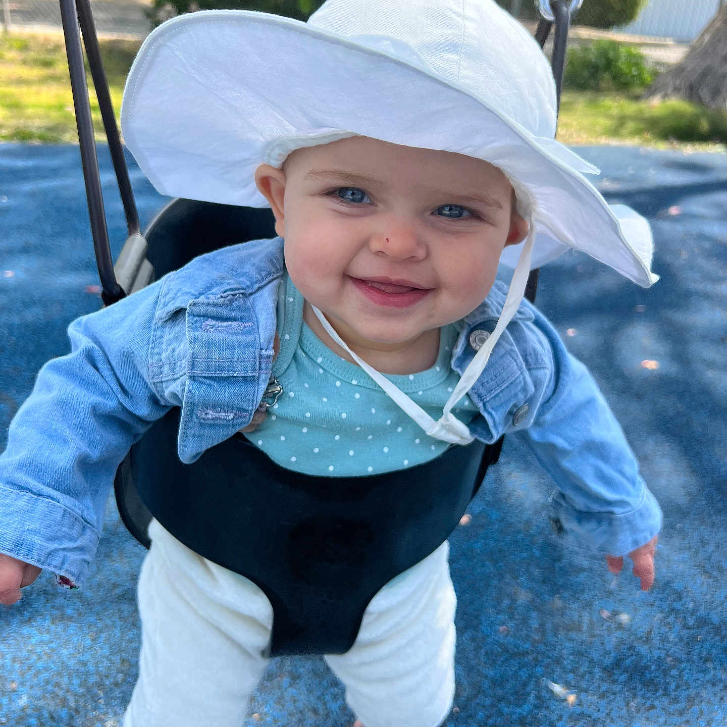 Zoe joined the competition — help win amazing prizes! baby, barefoot, blue_eyes, child, clothing, cute, denim_jacket, fun, happy, hat, infant, joyful, outdoor, park, person, playground, smile, summer, sun_hat, swing