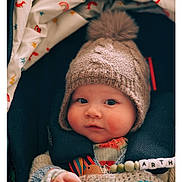 Arthur joined the competition — help win amazing prizes! baby, child, knitted_hat, pom_pom, blanket, colorful, pacifier_clip, face, chubby_cheeks, curious_expression, cozy, warm_clothing, indoor, portrait, infant, cute, soft_lighting, close_up, seated, person
