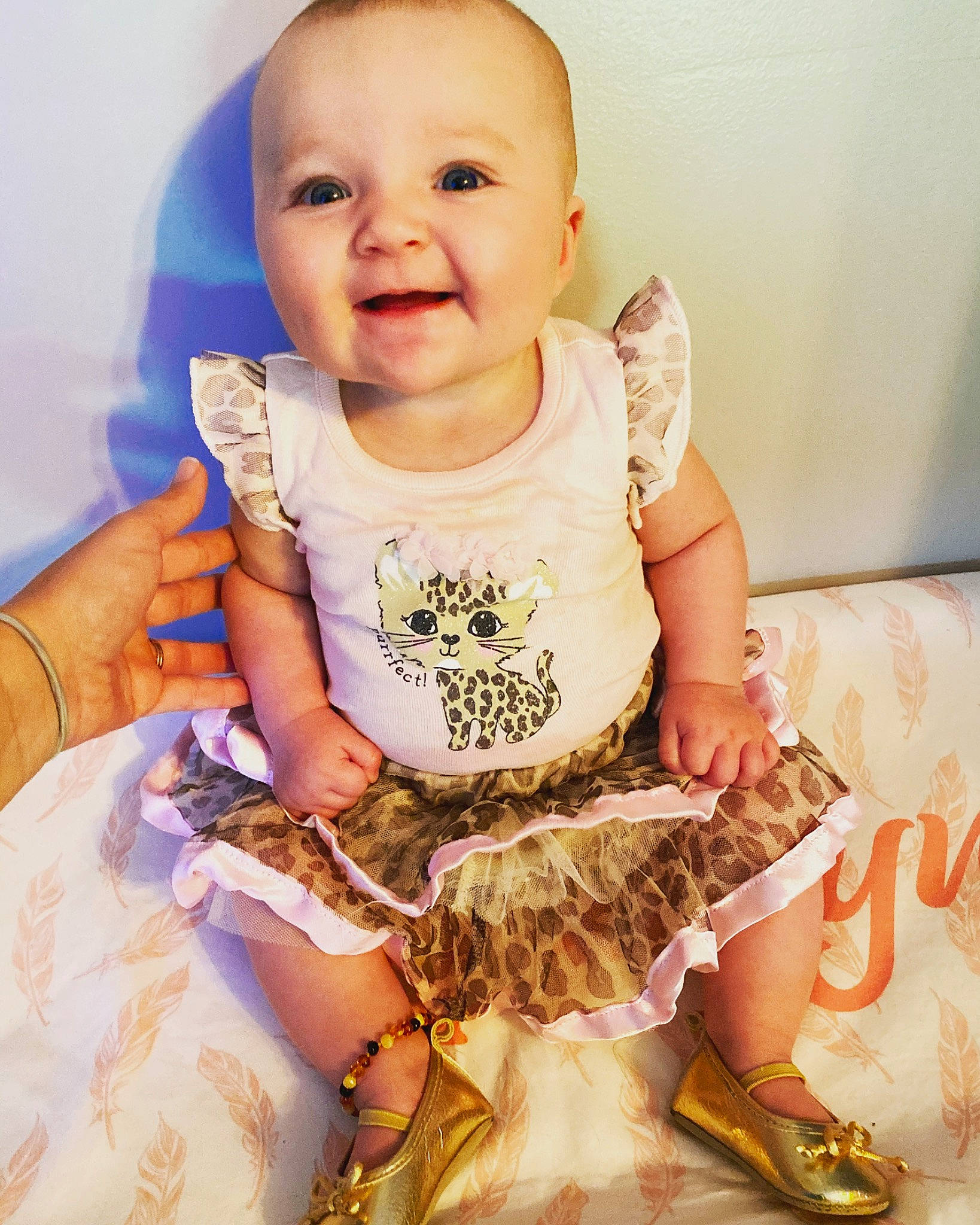 Harlyn is registered to the contest to win money with this photo: baby, baby_toddler_clothing, child, fashion_design, gesture, happy, human_leg, iris, neck, pattern, person, pink, sitting, skin, sleeve, smile, t_shirt, thigh, thumb, toddler
