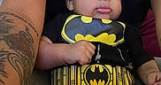 Jacyeon joined the competition — help win amazing prizes! arm, baby, baby_clothing, batman, black_shirt, cute, expression, eyes, face, hand, holding, indoor, infant, lap, legs, person, seated, skin, tattoo, yellow_logo