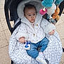 baby, clothing, coat, crib, face, footwear, furniture, glove, head, infantbed, jacket, knitwear, pants, person, photography, portrait, shoe, stroller, sweater, toy
