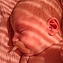 baby, blanket, closeup, ear, face, head, indoors, infant, light, newborn, pacifier, peaceful, portrait, resting, shadow, skin, sleeping, soft_light, striped_shadow, texture