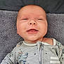 Connor is registered to the contest to win money with this photo: baby, infant, smile, face, onesie, blanket, sleepwear, happy, child, portrait, young, cute, clothing, skin, head, lying_down, soft_texture, baby_garment, relaxation, indoor