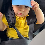 Ghaith participe au concours pour gagner de l'argent avec cette photo : baby, blue_cap, car_interior, car_seat, casual, child, child_safety, clothing, cute, denim_shorts, face, hand, hat, portrait, safety, seatbelt, summer, toddler, yellow_shirt, young_child