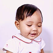 Stella participe au concours pour gagner de l'argent avec cette photo : baby, infant, child, portrait, smile, smiling, short_hair, black_hair, collar, white_background, soft_lighting, close_up, eyelashes, cheek, dress, sitting, cute, happy, skin, studio_photo