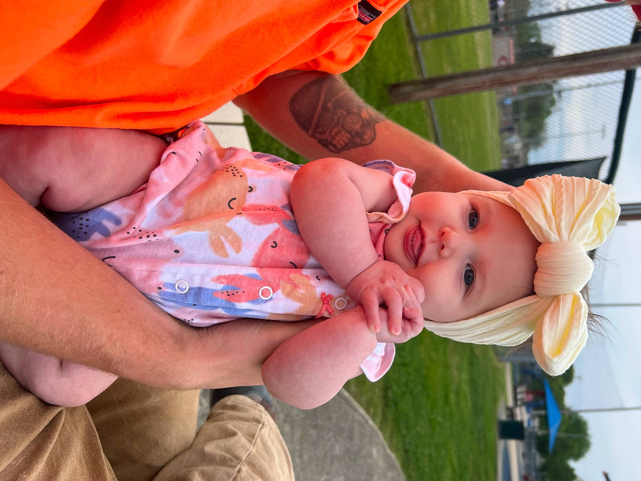 Felicity is registered to the contest to win money with this photo: baby, baby_toddler_clothing, child, dress, finger, gesture, grass, hand, happy, hat, headwear, lip, nose, orange, person, pink, plant, skin, smile, summer