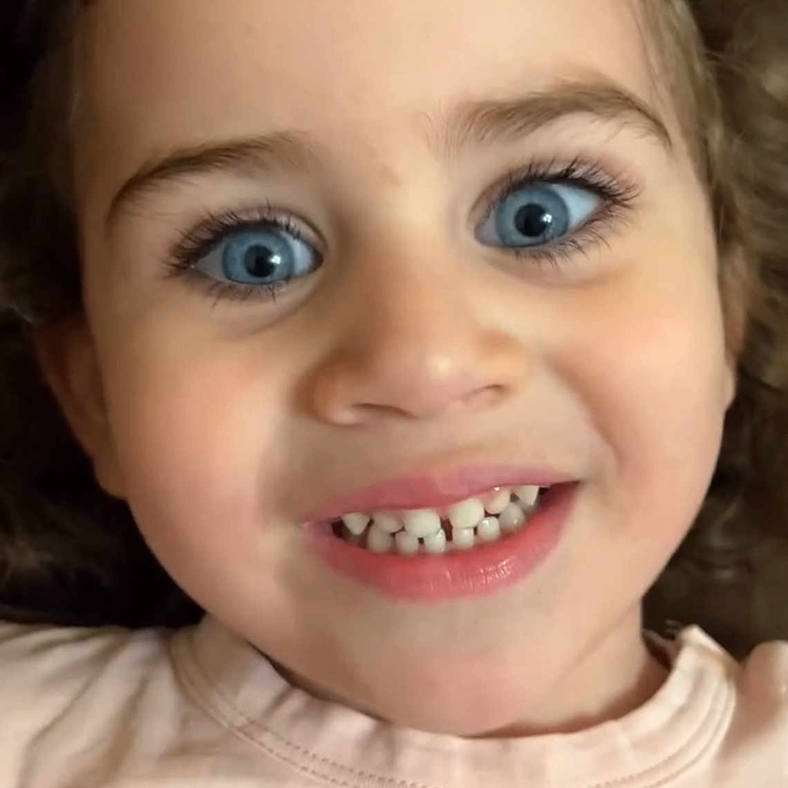 Eliza joined the competition — help win amazing prizes! child, face, blue_eyes, smile, teeth, young, portrait, closeup, happy, curly_hair, person, skin, eyelashes, clothing, casual, pink_shirt, expression, cute, childhood, innocence