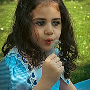 Eliza is registered to the contest to win money with this photo: child, girl, dandelion, blue_dress, curly_hair, outdoor, nature, greenery, flower, portrait, young, cute, sunlight, grass, summer, whimsical, peaceful, innocence, close_up, playful