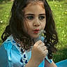 child, girl, dandelion, blue_dress, curly_hair, outdoor, nature, greenery, flower, portrait, young, cute, sunlight, grass, summer, whimsical, peaceful, innocence, close_up, playful
