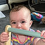 baby, child, infant, playing, wooden_toy, colorful_clothing, striped_shirt, flower_patch, indoor, carpet, toy, furniture, curious, grip, face, hand, smiling, eyes, head, person