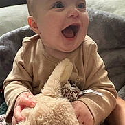 Scarlett joined the competition — help win amazing prizes! baby, child, infant, smiling, happy, stuffed_animal, plush_toy, blanket, cozy, indoors, person, cute, soft, clothing, hand, face, head, sitting, joy, warm