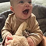 baby, child, infant, smiling, happy, stuffed_animal, plush_toy, blanket, cozy, indoors, person, cute, soft, clothing, hand, face, head, sitting, joy, warm