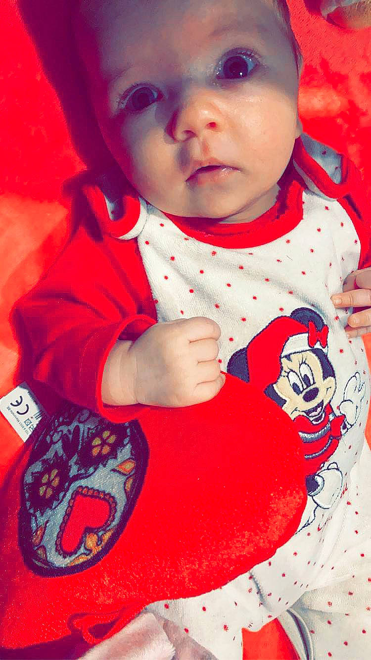 Elyana participe au concours pour gagner de l'argent avec cette photo : arm, baby, baby_toddler_clothing, cheek, chin, dress, face, hairstyle, head, lip, mouth, neck, nose, outerwear, person, pink, product, red, skin, sleeve