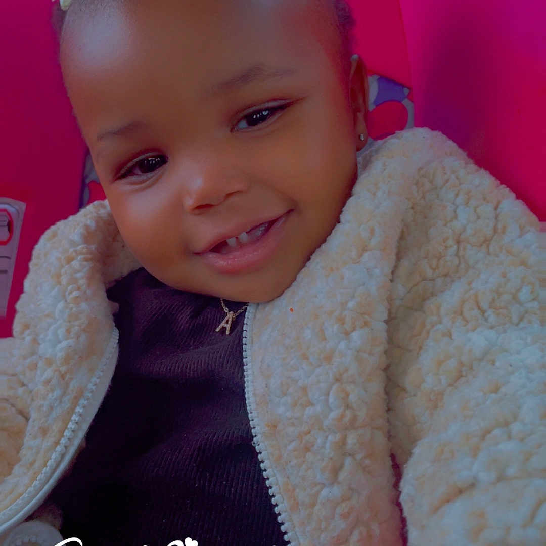 Amaris is registered to the contest to win money with this photo: accessories, baby, bodypart, bonnet, clothing, couch, cushion, face, finger, furniture, happy, hat, head, homedecor, knitwear, person, photography, portrait, smile, sweater