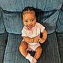 Layla joined the competition — help win amazing prizes! baby, child, smiling, pink_clothing, socks, bracelet, couch, blue_couch, striped, happy, sitting, indoors, portrait, cute, young_child, person, fashion, hair_braids, infant, comfortable