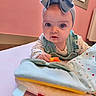 baby, child, headband, blue_eyes, toy, fabric, hand, pink_wall, window, indoor, soft_surface, curious, infant, clothing, colorful, cute, portrait, closeup, baby_girl, playtime