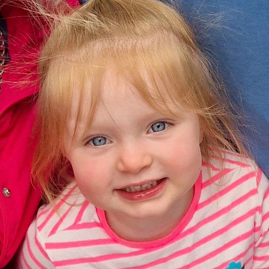 Poppy is registered to the contest to win money with this photo: blonde, bodypart, child, clothing, coat, face, female, girl, hair, happy, head, jacket, laughing, mouth, person, photography, portrait, smile, t_shirt, teeth
