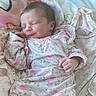 Mia is registered to the contest to win money with this photo: baby, bed, bedding, blanket, closed_eyes, cozy, face, family_photo, floral_clothing, hands, indoors, infant, nap, newborn, pastel, patterned_fabric, peaceful, pink, portrait, sleeping