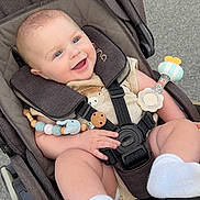 Hudson joined the competition — help win amazing prizes! baby, stroller, smiling, infant, toy, rattle, blue_eyes, seatbelt, clothing, sock, cute, child, outside, happy, face, hand, foot, comfort, quilted, person