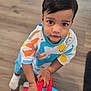 toddler, child, toy, walker, floor, wooden_floor, indoor, clothing, colorful, hands, face, person, young_child, curious, standing, play, bright_colors, socks, short_sleeve_shirt, blue_pants