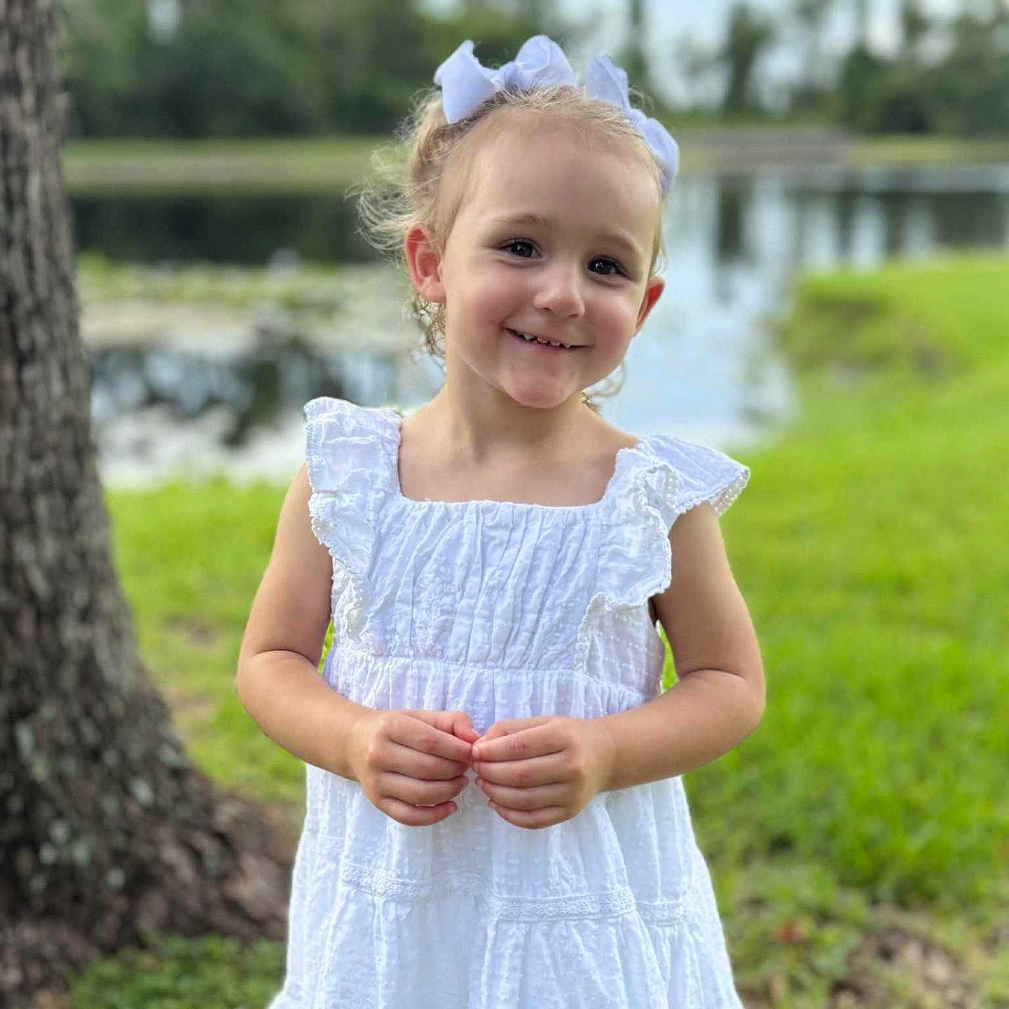 Autumn is registered to the contest to win money with this photo: bows, child, cute, daylight, fashion, girl, grass, greenery, happy, nature, outdoor, person, playful, pond, portrait, smiling, summer, tree, white_dress, young_child
