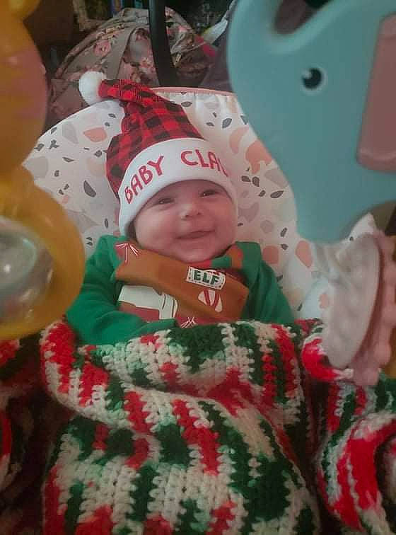 Alexandria is registered to the contest to win money with this photo: baby, baby_toddler_clothing, cap, carmine, child, christmas, christmas_eve, event, eye, fictional_character, fun, happy, headwear, holiday, joy, linens, pattern, person, room, sleeve