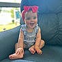 baby, child, smiling, headband, red_bow, armchair, blue_fabric, striped_outfit, happy, sitting, indoors, window, blurred_background, cute, infant, hands, feet, portrait, person, bright_eyes