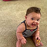 Isabella is registered to the contest to win money with this photo: baby, child, smiling, toy, carpet, striped_clothing, indoor, cute, happy, sitting, cheeks, person, playful, infant, holding, young_child, portrait, bright_eyes, cute_expression, small_toy