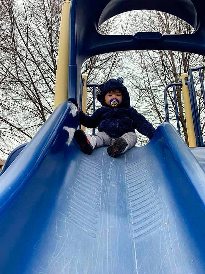 Emmanuel is registered to the contest to win money with this photo: beauty, chute, comfort, electric_blue, jacket, leg, leisure, natural_environment, outdoor_play_equipment, outdoor_recreation, outerwear, person, playground, public_space, recreation, shoe, smile, sneakers, sunglasses, toddler