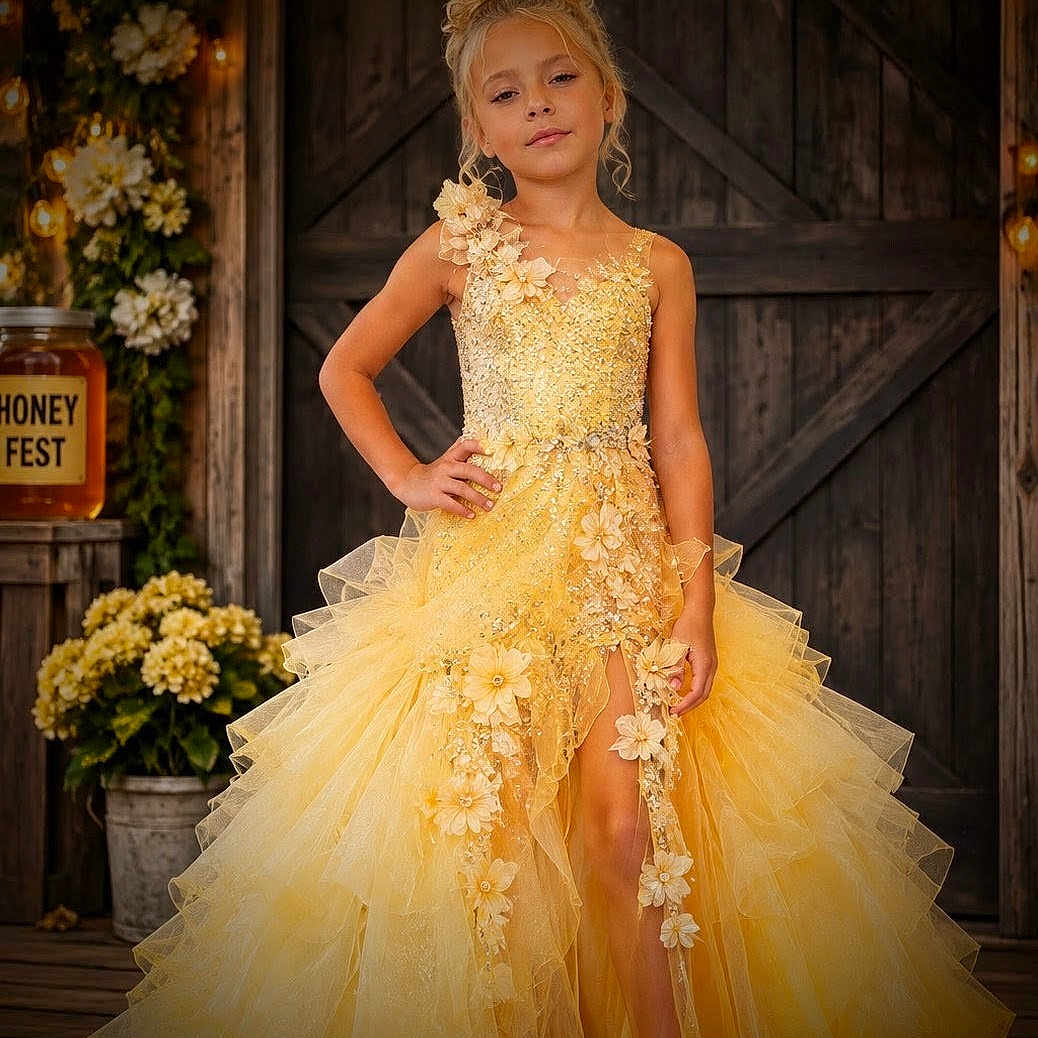 Kyria is registered to the contest to win money with this photo: child, girl, yellow_dress, dress, flowers, flower_decor, rustic, wooden_background, string_lights, elegant, pose, portrait, fashion, young, smiling, event, celebration, outdoor, wooden_floor, confident