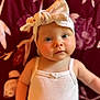 baby, infant, headband, white_clothing, portrait, face, eyes, skin, cute, child, person, indoors, soft_light, background, floral_pattern, tank_top, fashion, headwear, closeup, adorable
