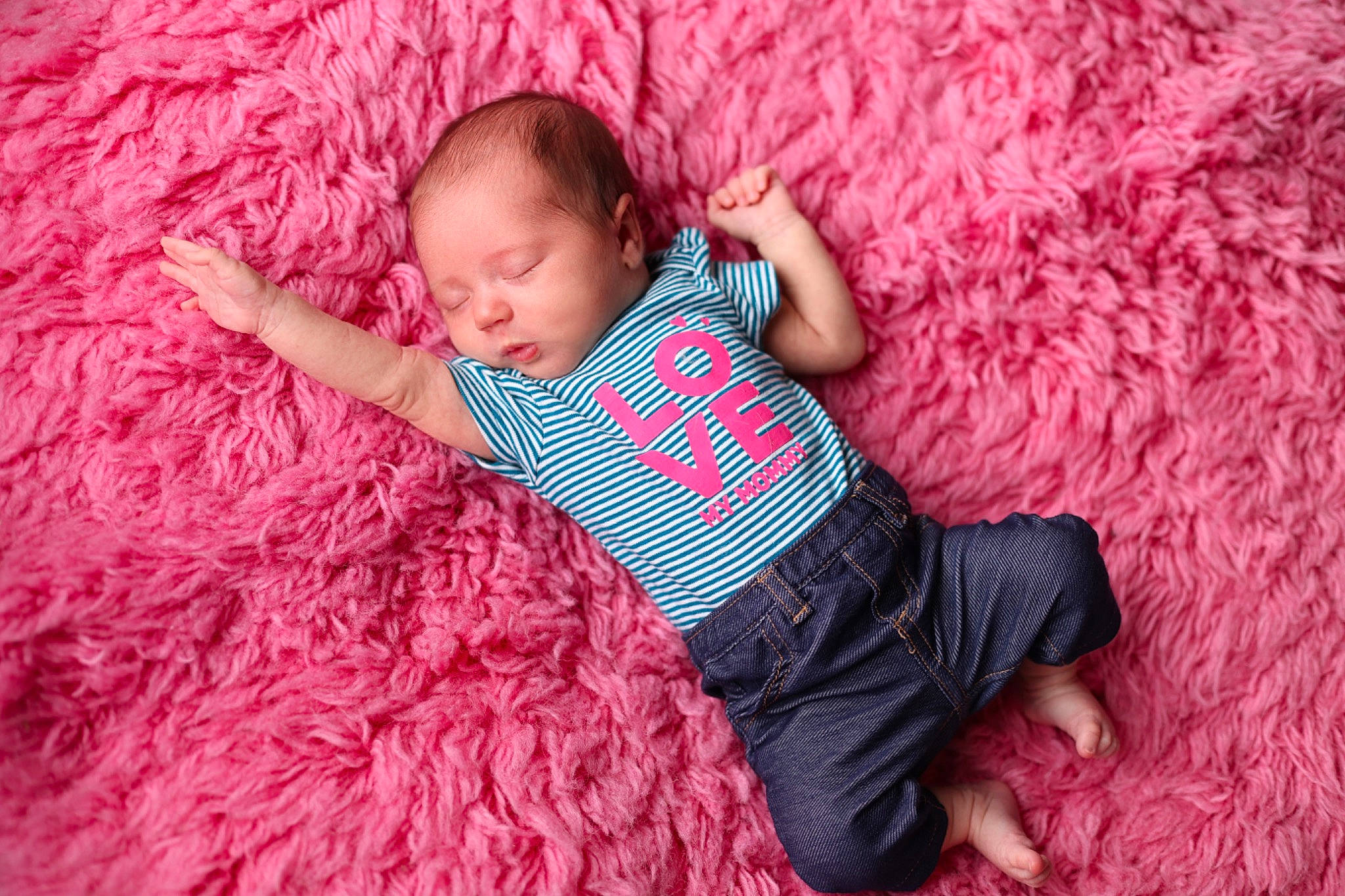 Emersyn is registered to the contest to win money with this photo: arm, baby, baby_toddler_clothing, comfort, finger, flooring, grass, human_leg, linens, magenta, pattern, person, pink, purple, red, skin, sleeve, t_shirt, textile, thigh