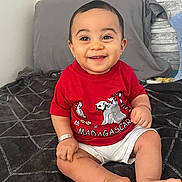 Giovanni a rejoint le concours — aidez-le/la à gagner de superbes lots ! baby, child, smiling, red_shirt, madagascar, shorts, sitting, bed, happy, indoors, person, infant, cute, portrait, skin, foot, hand, face, clothing, young
