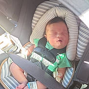 Ellie is registered to the contest to win money with this photo: baby, sleeping, car_seat, seatbelt, harness, infant, newborn, hospital_bracelet, green_clothing, striped_cushion, footwear, pacifier, safety, child, transportation, car_interior, sunlight, peaceful, cute, resting
