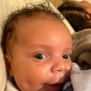 Djaeli participe au concours pour gagner de l'argent avec cette photo : baby, infant, newborn, face, eyes, dimples, smile, curly_hair, blanket, swaddle, close_up, portrait, cheek, skin, cuddly, bed, pillow, parent_in_background, braids, cozy