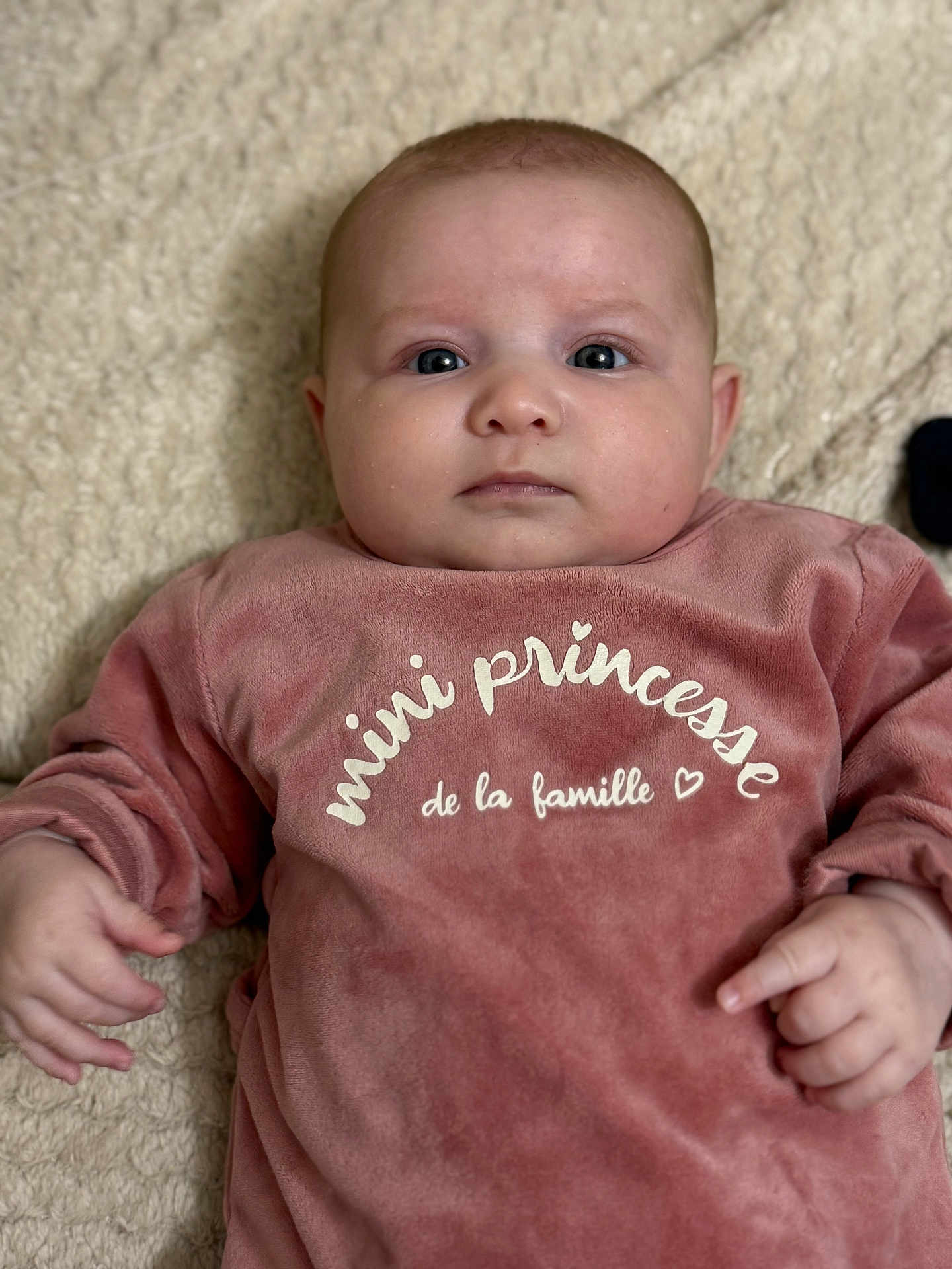 Luna participe au concours pour gagner de l'argent avec cette photo : baby, infant, child, pink_clothing, face, eyes, hands, blanket, soft_texture, portrait, cute, indoors, lying_down, expressionless, skin, newborn, person, apparel, warm, cozy