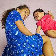 Hanah is registered to the contest to win money with this photo: children, siblings, baby, toddler, girl, infant, sister, bed, bedroom, lying_down, smiling, portrait, floral_dress, blue_dress, pink_outfit, curly_hair, long_hair, family, indoor, happy