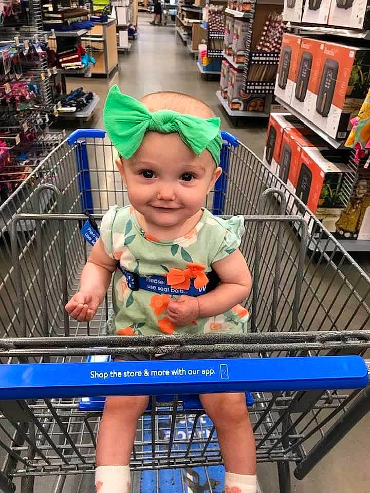 Alexandria is registered to the contest to win money with this photo: baby, blue, building, child, city, electric_blue, event, fun, headwear, human_leg, joy, leisure, outdoor_bench, outdoor_furniture, person, product, recreation, retail, shelf, shopping