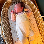 Avery joined the competition — help win amazing prizes! baby, infant, basket, bassinet, woven, overalls, clothing, sleeping_area, floral_pattern, mattress, newborn, person, indoor, soft_light, curious, hand, foot, head, skin, cute