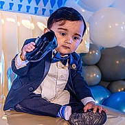 Siraj joined the competition — help win amazing prizes! baby, balloons, blue, bow_tie, boy, celebration, child, couch, curious, cute, formal_wear, gray, indoor, party, portrait, shoe, smile, suit, toddler, white