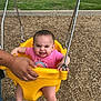 baby, child, swing, playground, park, yellow_swing, pink_shirt, rainbow, smiling, happy, grass, woodchips, hand, person, outdoor, fun, legs, barefoot, metal_chains, summer