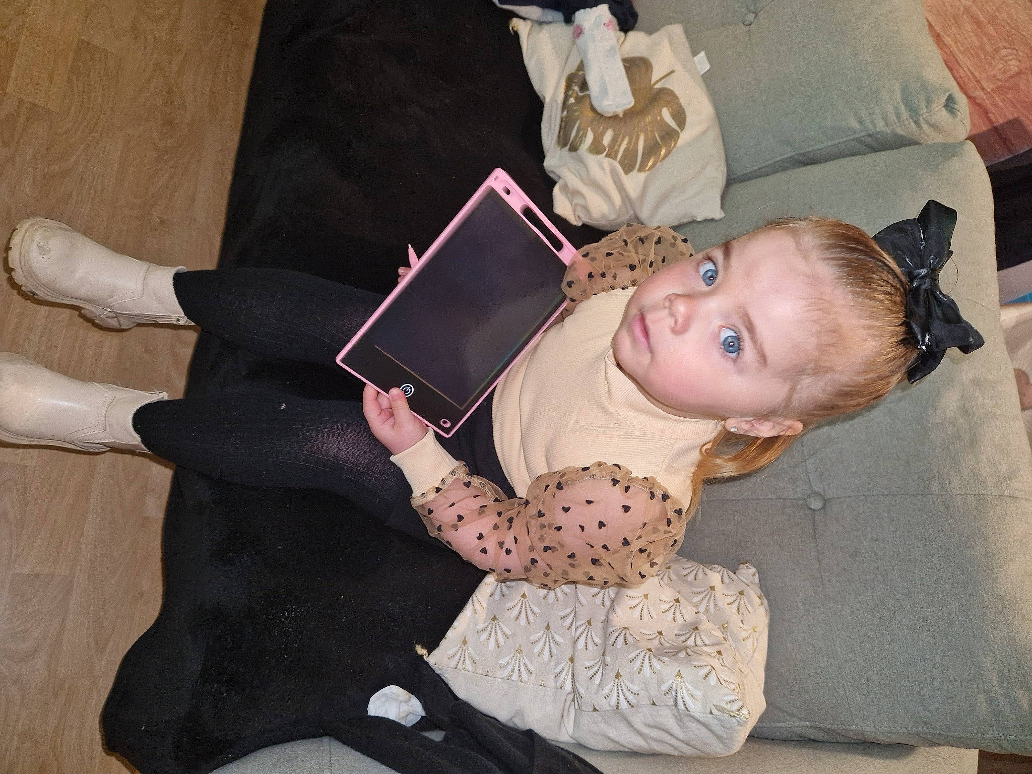 Lya a rejoint le concours — aidez-le/la à gagner de superbes lots ! baby_toddler_clothing, comfort, fashion_accessory, flooring, foot, formal_wear, fun, gesture, happy, human_leg, jewellery, knee, lap, pattern, person, sitting, sleeve, thigh, toddler, wood